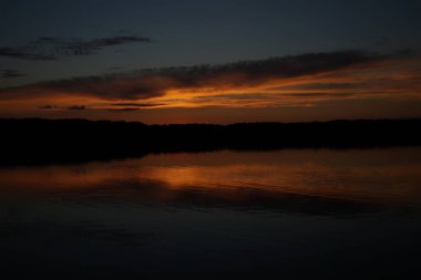 Sabahın erken saatlerinde gölün üzerinde sonsuz karanlık gökyüzü manzarası.   