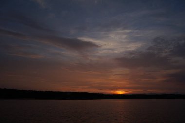Gün batımının resimsel görüntüsü gölün ayna yüzeyine yansıyor 