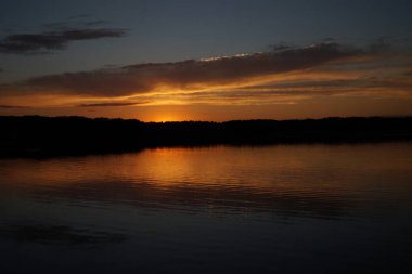 Sabahın erken saatlerinde gölün üzerinde sonsuz karanlık gökyüzü manzarası.   