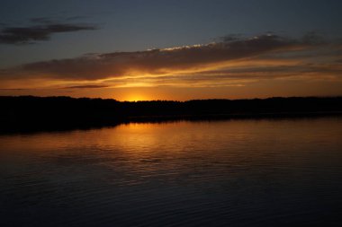 Sabahın erken saatlerinde gölün üzerinde sonsuz karanlık gökyüzü manzarası.   
