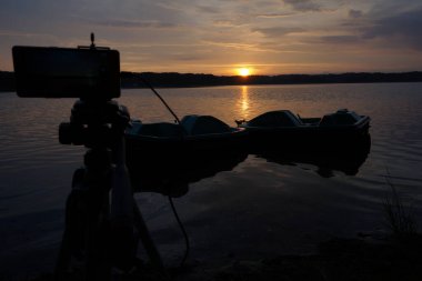 Gün batımının resimsel görüntüsü gölün ayna yüzeyine yansıyor 