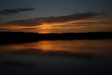 Sabahın erken saatlerinde gölün üzerinde sonsuz karanlık gökyüzü manzarası.   