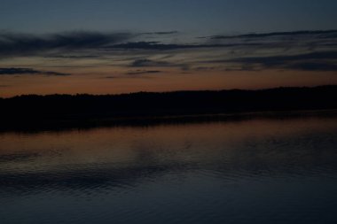 Sabahın erken saatlerinde gölün üzerinde sonsuz karanlık gökyüzü manzarası.   