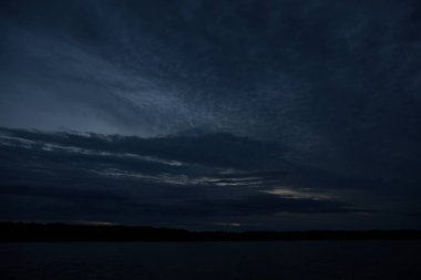 Sabahın erken saatlerinde gölün üzerinde sonsuz karanlık gökyüzü manzarası.   