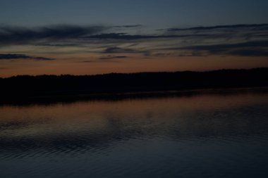 Sabahın erken saatlerinde gölün üzerinde sonsuz karanlık gökyüzü manzarası.   