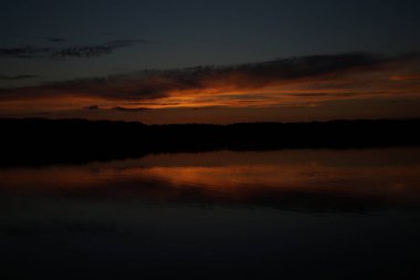 Sabahın erken saatlerinde gölün üzerinde sonsuz karanlık gökyüzü manzarası.   