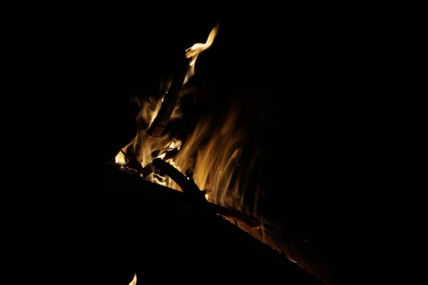 Feuer brennt Bäume in der Nacht. Große orangefarbene Flamme isoliert auf schwarzem Hintergrund. Feuer auf schwarz. Hell, Hitze, Licht, Zelten, großes Lagerfeuer — Stockfoto