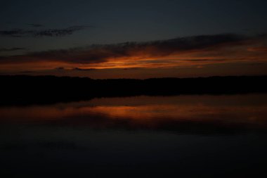 Sabahın erken saatlerinde gölün üzerinde sonsuz karanlık gökyüzü manzarası.   