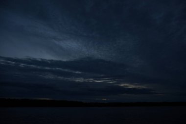 Sabahın erken saatlerinde gölün üzerinde sonsuz karanlık gökyüzü manzarası.   