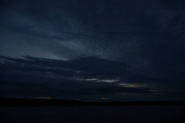 Sabahın erken saatlerinde gölün üzerinde sonsuz karanlık gökyüzü manzarası.   