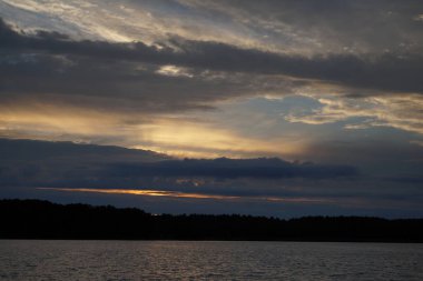 Sabahın erken saatlerinde gölün üzerinde sonsuz karanlık gökyüzü manzarası.   