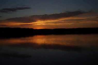 Sabahın erken saatlerinde gölün üzerinde sonsuz karanlık gökyüzü manzarası.   