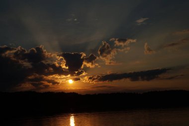 Gün batımının resimsel görüntüsü gölün ayna yüzeyine yansıyor 