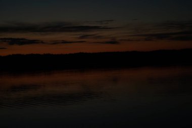 Sabahın erken saatlerinde gölün üzerinde sonsuz karanlık gökyüzü manzarası.   