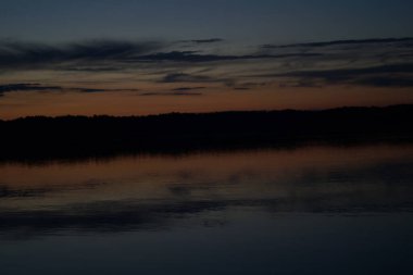 Sabahın erken saatlerinde gölün üzerinde sonsuz karanlık gökyüzü manzarası.   