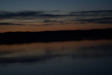 Sabahın erken saatlerinde gölün üzerinde sonsuz karanlık gökyüzü manzarası.   