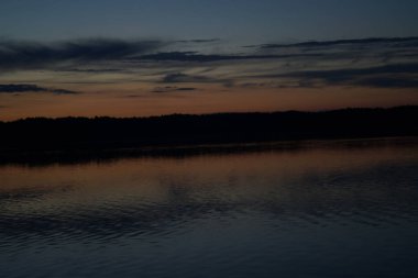 Sabahın erken saatlerinde gölün üzerinde sonsuz karanlık gökyüzü manzarası.   