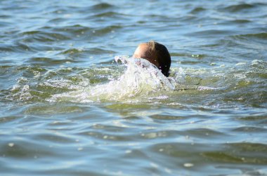 Gölde yüzen küçük bir kız.