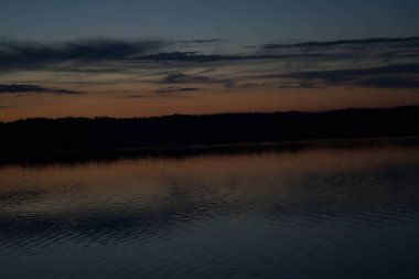 Sabahın erken saatlerinde gölün üzerinde sonsuz karanlık gökyüzü manzarası.   