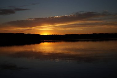 Sabahın erken saatlerinde gölün üzerinde sonsuz karanlık gökyüzü manzarası.   