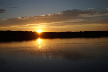Sabahın erken saatlerinde gölün üzerinde sonsuz karanlık gökyüzü manzarası.   