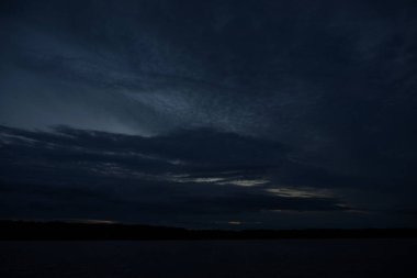 Sabahın erken saatlerinde gölün üzerinde sonsuz karanlık gökyüzü manzarası.   