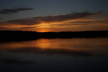 Sabahın erken saatlerinde gölün üzerinde sonsuz karanlık gökyüzü manzarası.   