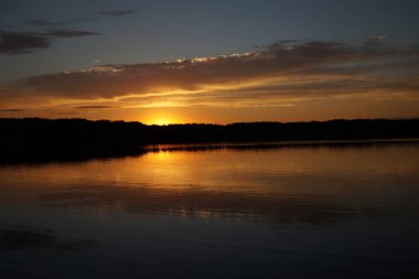 Sabahın erken saatlerinde gölün üzerinde sonsuz karanlık gökyüzü manzarası.   
