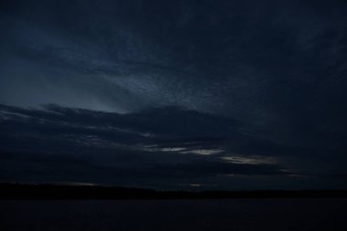 Sabahın erken saatlerinde gölün üzerinde sonsuz karanlık gökyüzü manzarası.   