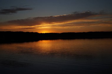 Sabahın erken saatlerinde gölün üzerinde sonsuz karanlık gökyüzü manzarası.   
