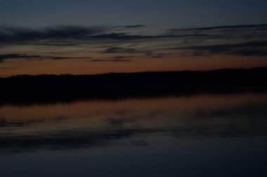 Sabahın erken saatlerinde gölün üzerinde sonsuz karanlık gökyüzü manzarası.   