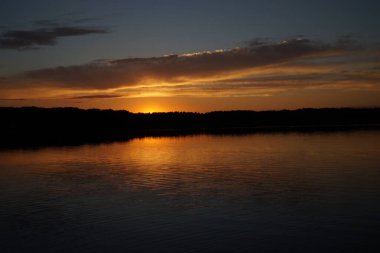 Sabahın erken saatlerinde gölün üzerinde sonsuz karanlık gökyüzü manzarası.   