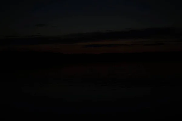 早朝の湖の上の果てしなく続く暗い空の絵のような景色 — ストック写真