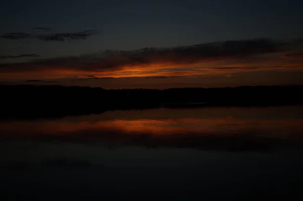 早朝の湖の上の果てしなく続く暗い空の絵のような景色 — ストック写真