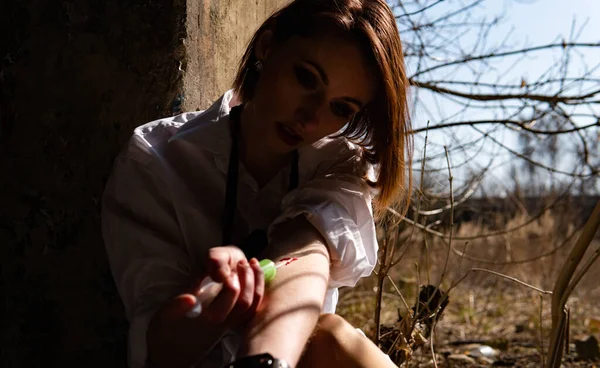 Terk edilmiş evde uyuşturucu alan genç bir kadın.