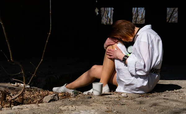 Terk edilmiş bir yerde oturan beyaz gömlekli güzel bir kadın.