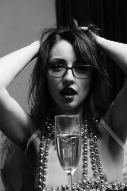 Dekoratif melek kanatları takan çıplak bir kadın. Karanlık arka planda poz veriyor.    