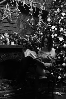 Güzel çıplak kadın Noel süslemeli odada poz veriyor.   