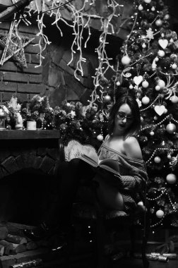 Güzel çıplak kadın Noel süslemeli odada poz veriyor.   