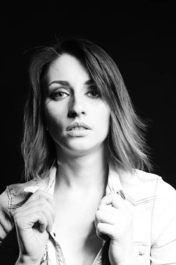 Koyu arkaplanda poz veren güzel bir kadın.  