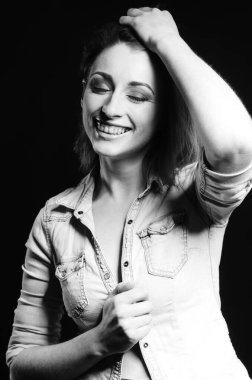 Koyu arkaplanda poz veren güzel bir kadın.  