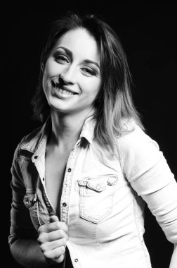 Koyu arkaplanda poz veren güzel bir kadın.  