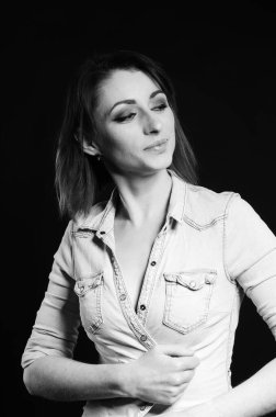 Koyu arkaplanda poz veren güzel bir kadın.  