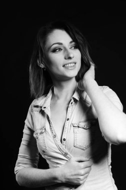 Koyu arkaplanda poz veren güzel bir kadın.  