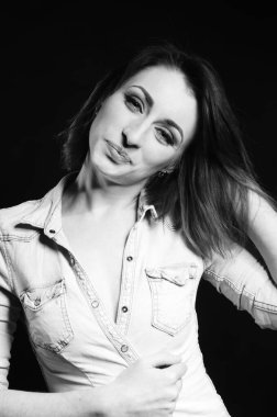 Koyu arkaplanda poz veren güzel bir kadın.  