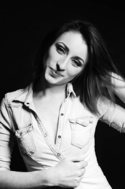 Koyu arkaplanda poz veren güzel bir kadın.  