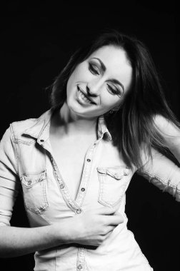 Koyu arkaplanda poz veren güzel bir kadın.  