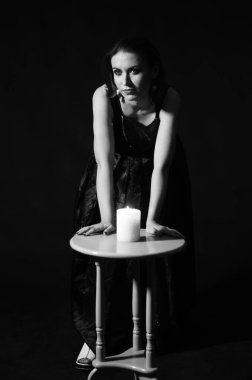 Makyajlı kadın koyu arka planda mum ile poz veriyor, Cadılar Bayramı konsepti 