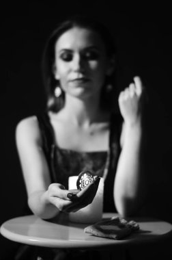 Masada oturan makyajlı kadın koyu arka planda mum, Cadılar Bayramı konsepti 