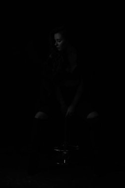 Sütyen ve kürk giymiş seksi bir kadın, siyah beyaz bir fotoğraf.